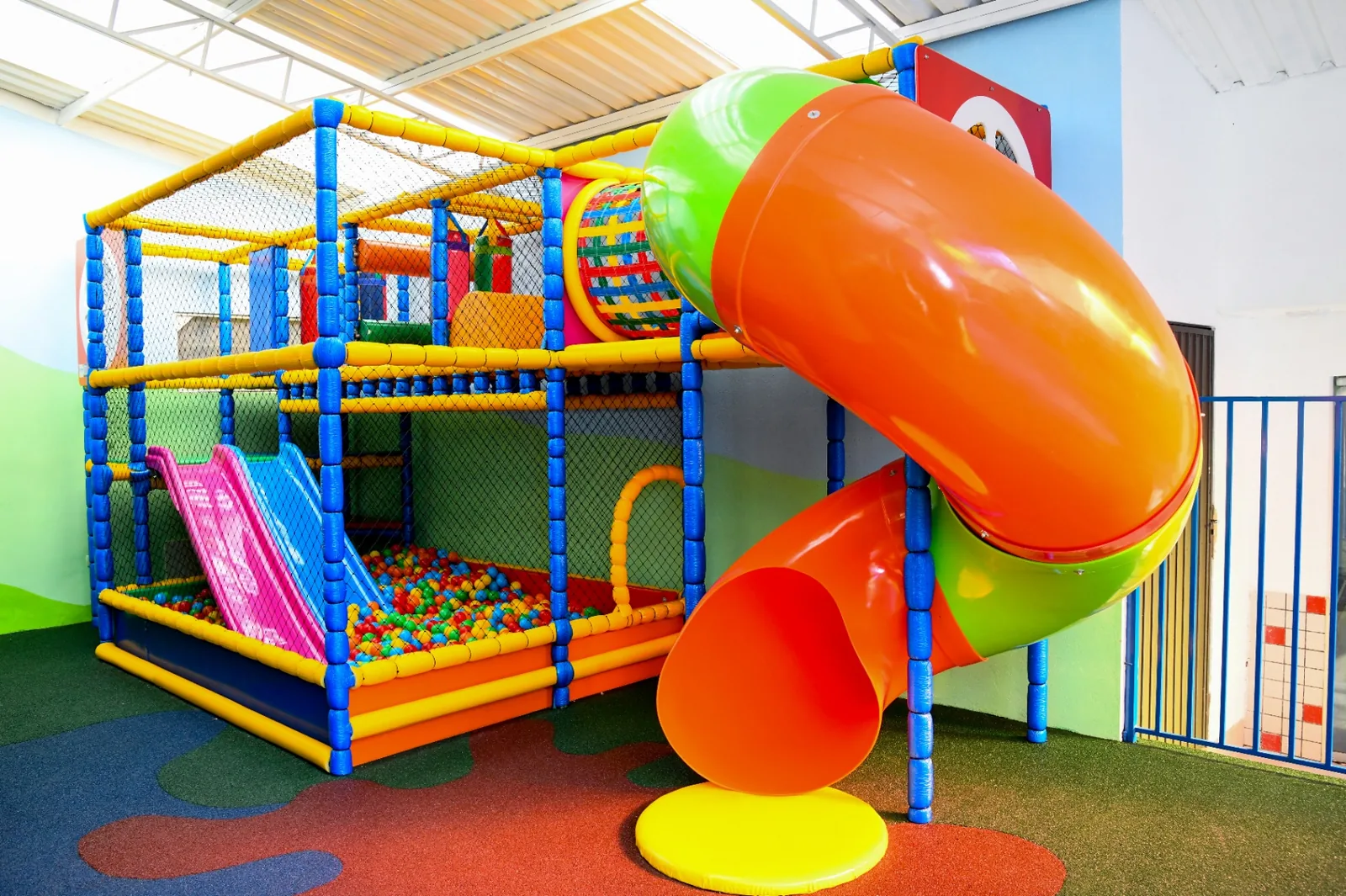 Parque infantil coberto com escorregador e estrutura de recreação